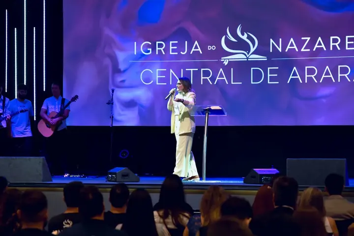 Louvor durante o culto, com o nome da igreja no telão